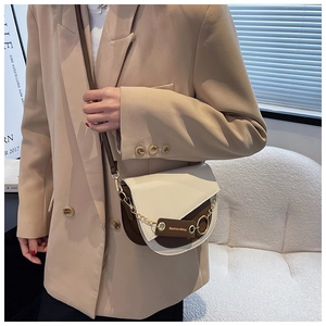 Detail of retro color-block saddle bag with gold chain and fashion leather tag