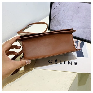 Detail view of the brown leather accordion pleated side structure of the crossbody bag