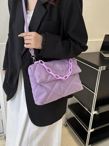 Détail du sac bandoulière en nylon matelassé violet avec motif de losanges et chaîne