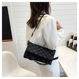 Detail of black checkered crossbody bag with thick acrylic chain and adjustable strap