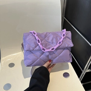 Détail du sac en nylon matelassé violet avec coutures en losanges et grosse chaîne