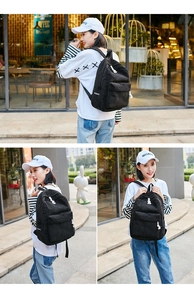 Detailed view of black corduroy backpack with sturdy shoulder straps and large front pocket