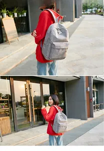 Close-up of grey corduroy backpack showing large capacity and front pocket on a model