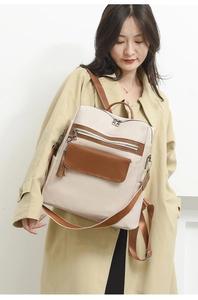 Detail of beige PU backpack showing brown fringe pocket and versatile detachable strap