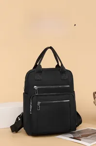 Detail of black waterproof oxford backpack with multiple silver metal zipper pockets