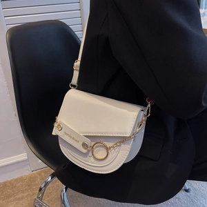 Chic white semi-circle saddle bag with gold chain strap on black blazer outfit