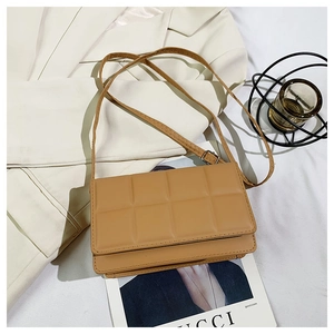Detail of camel quilted crossbody bag with adjustable strap on white suit background