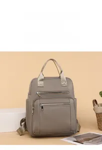 Detail view of stylish beige quilted backpack with multiple compartments and durable handles