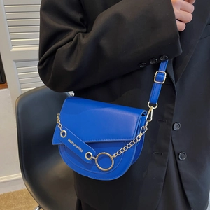 Royal blue saddle crossbody bag with gold chain and strap worn on a black blazer