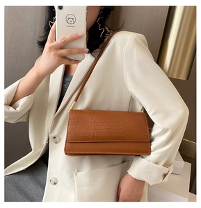 Detailed view of brown crocodile texture on a chic rectangular faux leather baguette bag