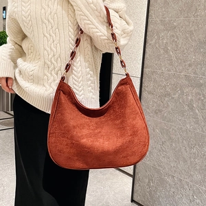 Minimalist caramel suede hobo bag with stylish amber resin chain and metal shoulder strap