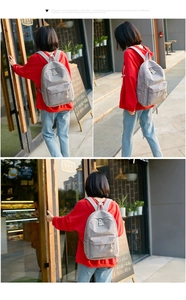 Detail of grey corduroy backpack showing thick ribbed texture and tassel zipper pocket
