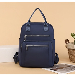 Close-up of deep blue nylon backpack with quilted stitching and dual zipper pockets