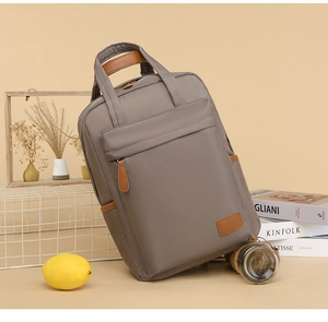 Detail of taupe waterproof backpack with brown leather handles and premium texture