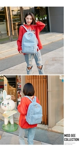 Detail of light blue corduroy backpack with retro texture and zipper pocket for women
