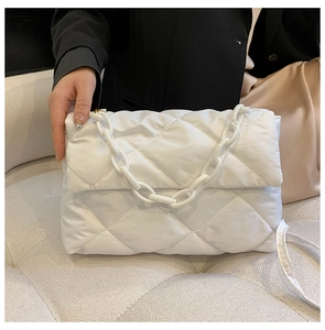 Détail du sac matelassé blanc avec une grosse chaîne en plastique et un tissu en nylon léger