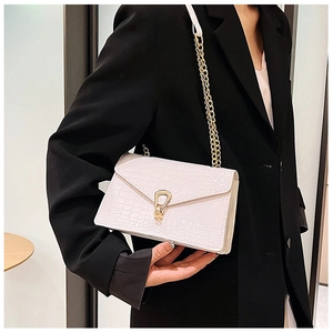 Detailed view of white crocodile pattern shoulder bag with gold metal teardrop clasp