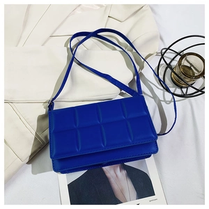 Macro view of navy blue quilted PU leather texture on the rectangular crossbody bag