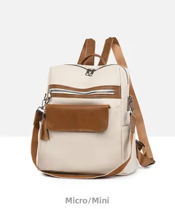 Side view of cream leather backpack with brown trim and tassel pocket detail