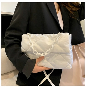 Gros plan d'un sac en nylon matelassé blanc avec chaîne épaisse en plastique