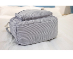 Close-up of light purple corduroy texture and white cotton rope zipper pull on a backpack
