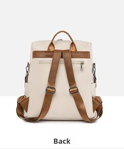 Detail view of the cream backpack's back side showing adjustable straps and zipper pocket