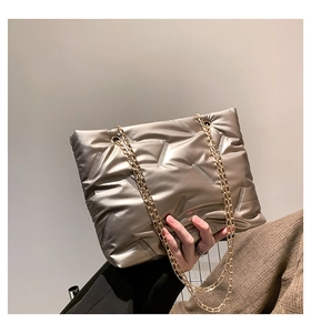 Detail of silver metallic quilted tote with chain strap and diagonal stitching