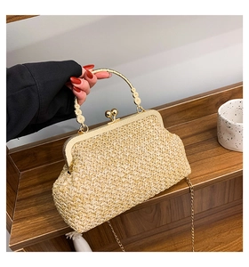 Detail of beige straw shell bag featuring metal flower handle and gold chain strap