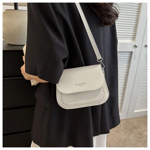 Vista dettagliata della borsa a tracolla beige con trama a coccodrillo e scritta fashion