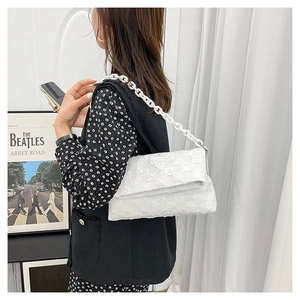Detail of white checkered crossbody bag with stylish thick plastic chain link strap