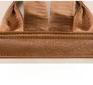 Detailed macro view of heavy-duty nylon strap and precision stitching on brown PU leather