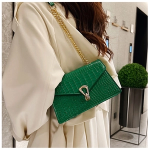 Detailed close-up of green crocodile texture shoulder bag with golden chain and U-lock