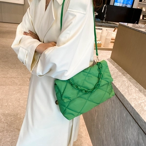 Sac à bandoulière matelassé en nylon vert herbe avec chaîne épaisse porté par un mannequin