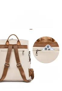 Detail view of anti-theft back zipper pocket on cream PU leather backpack with phone