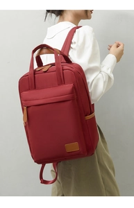 Side view of waterproof oxford cloth backpack in burgundy with dual handles and zippers