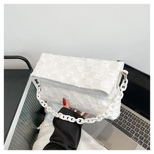 Detail of white quilted checkered handbag with chunky plastic chain strap and fold texture