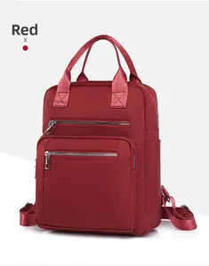 Detail view of red quilted nylon backpack featuring silver zippers and side pockets