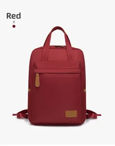 Detail view of red waterproof nylon backpack with brown leather accents and dual handles