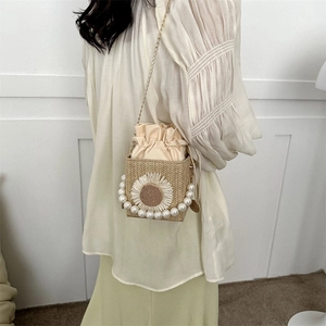 Woven straw bucket bag with sunflower appliqué and elegant pearl top handle