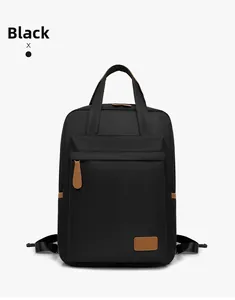 Detail view of black waterproof nylon backpack with brown leather zipper pulls and logo