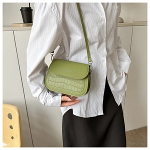 Dettaglio della borsa verde avocado con goffratura coccodrillo e scritta Fashion Trend