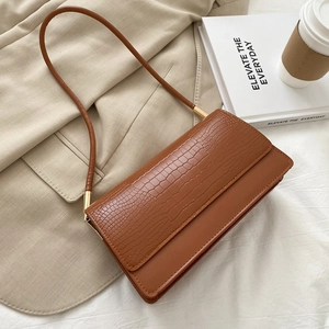 Brown crocodile pattern baguette shoulder bag with flap closure shown at a 45-degree angle