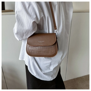 Dettaglio borsa a tracolla marrone vintage con texture coccodrillo e testo argento