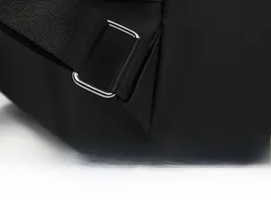 Close-up of reinforced triangle stitching and matte black metal buckle on backpack strap