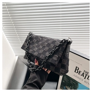 Detail of black checkered crossbody bag with thick resin chain strap and pleated fabric texture