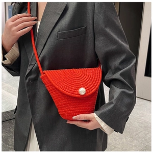 Close-up of orange hand-woven cotton rope bag with a large pearl button detail