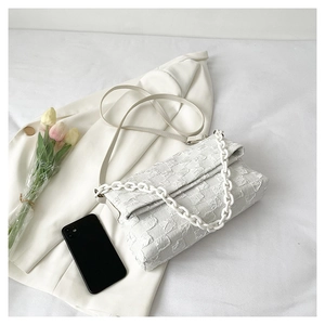 Detailed macro of white checkered pleated texture handbag with decorative resin chain