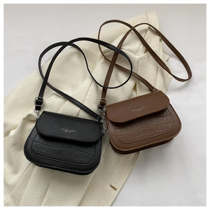 Dettaglio della trama a coccodrillo e scritta fashion sulla borsa a sella da donna