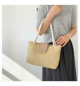 Détail du sac cabas en paille avec rabat en cuir marron et anses en corde blanche