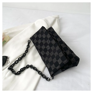 Detail of checkered pattern fabric and black chain strap on a rectangular crossbody bag